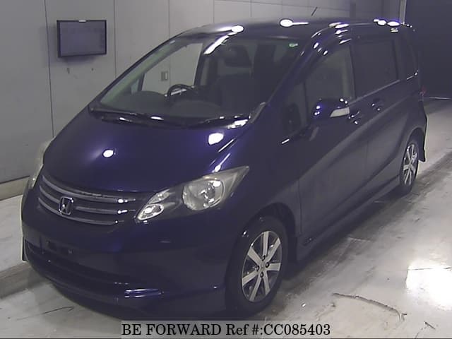 A grey sports car speeding down a highway at night.