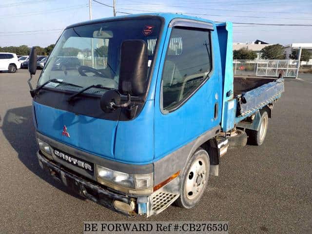 A grey JDM sports car speeding down a highway at night.