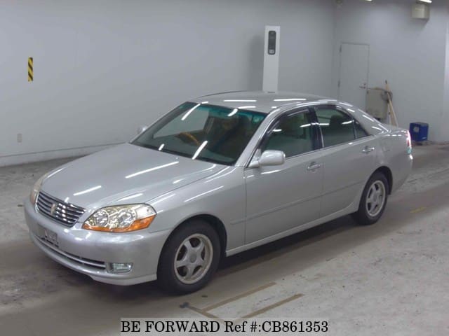 A grey JDM sports car speeding down a highway at night.