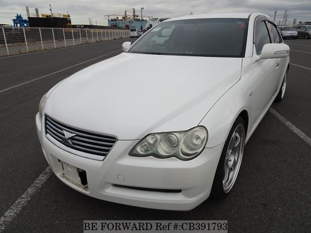 A grey JDM sports car speeding down a highway at night.