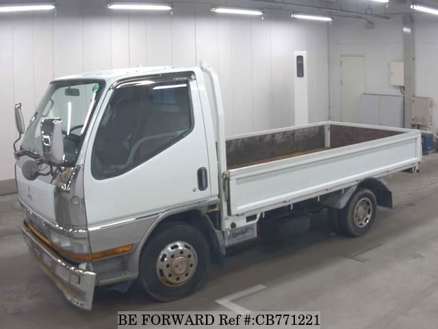 A grey JDM sports car speeding down a highway at night.