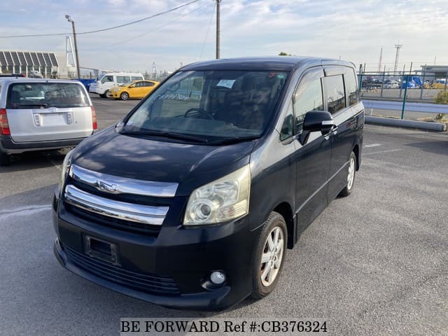A grey JDM sports car speeding down a highway at night.