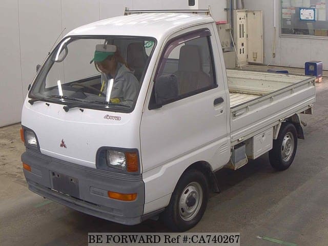 A grey JDM sports car speeding down a highway at night.