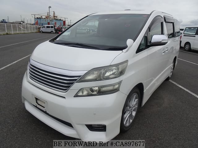 A grey JDM sports car speeding down a highway at night.
