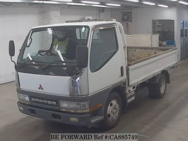 A grey JDM sports car speeding down a highway at night.