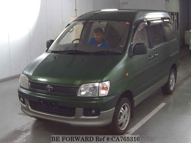 A grey JDM sports car speeding down a highway at night.