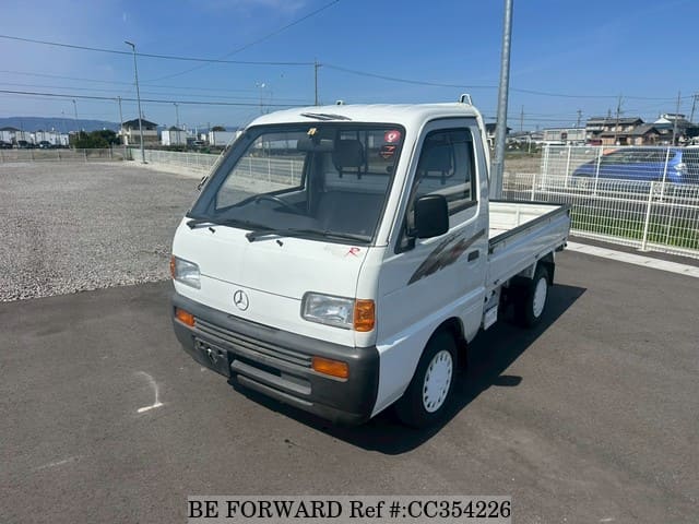 A grey sports car speeding down a highway at night.