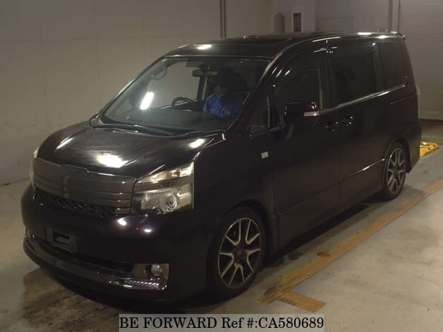 A grey JDM sports car speeding down a highway at night.