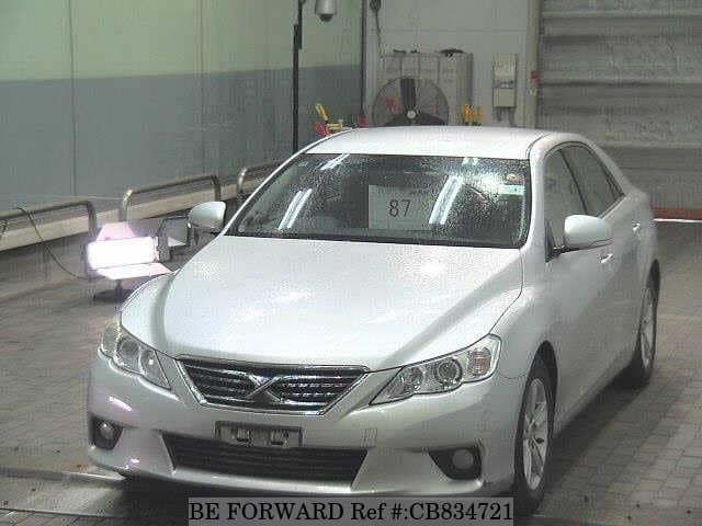 A grey JDM sports car speeding down a highway at night.