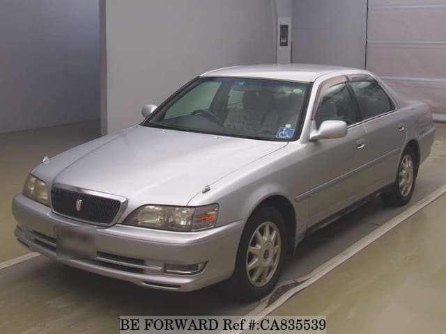 A grey JDM sports car speeding down a highway at night.
