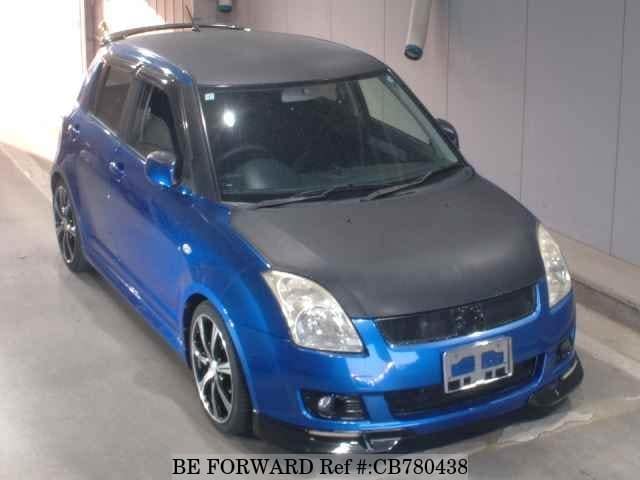 A grey JDM sports car speeding down a highway at night.