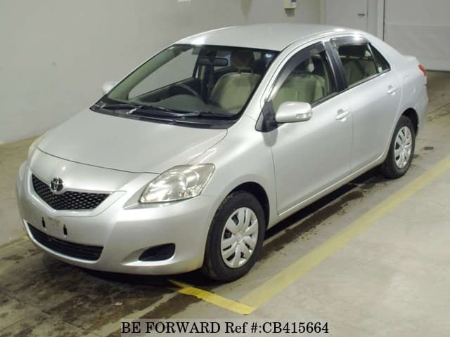 A grey sports car speeding down a highway at night.