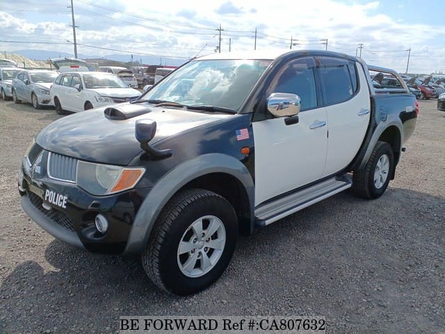 A grey JDM sports car speeding down a highway at night.