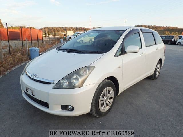 A grey JDM sports car speeding down a highway at night.