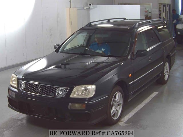 A grey JDM sports car speeding down a highway at night.