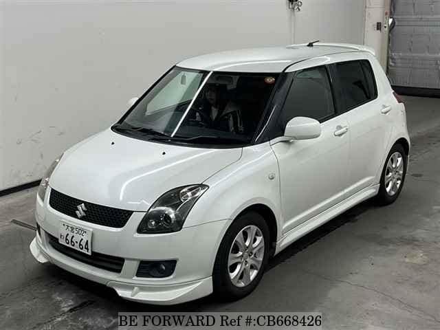 A grey JDM sports car speeding down a highway at night.
