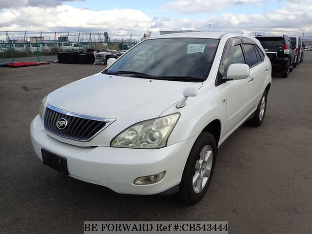A grey sports car speeding down a highway at night.