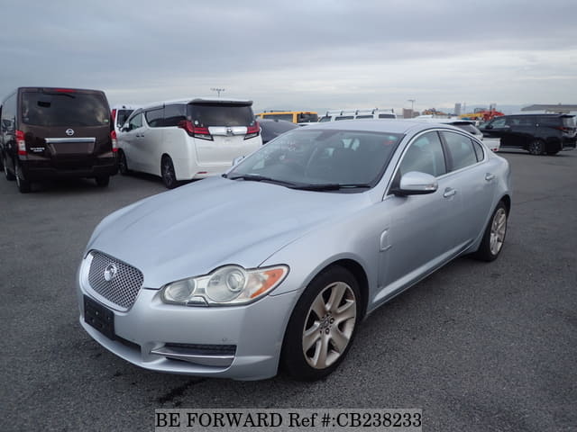 A grey JDM sports car speeding down a highway at night.