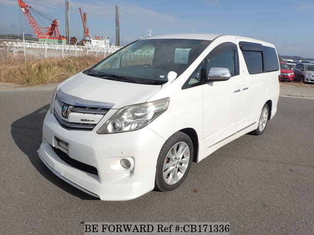 A grey JDM sports car speeding down a highway at night.