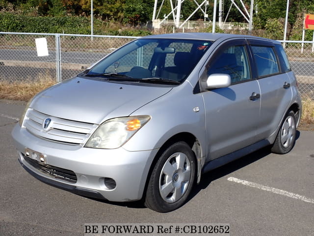 A grey JDM sports car speeding down a highway at night.