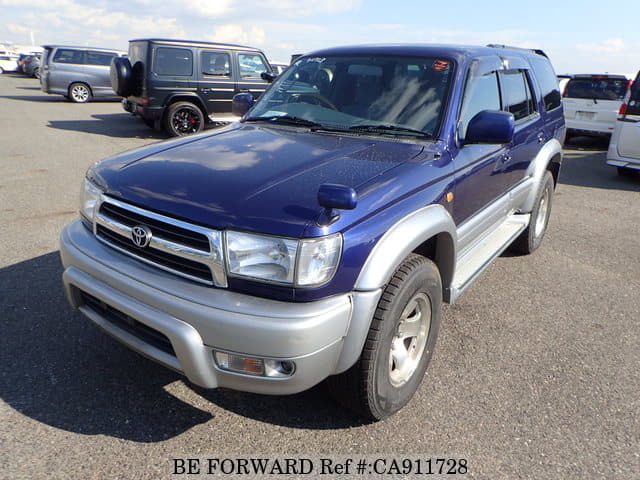 A grey sports car speeding down a highway at night.
