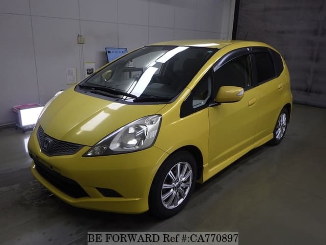 A grey JDM sports car speeding down a highway at night.