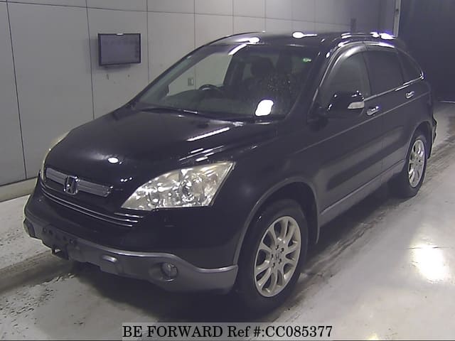 A grey sports car speeding down a highway at night.