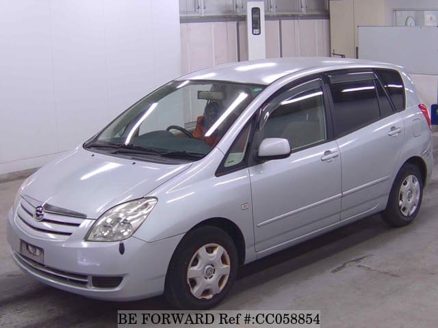 A grey sports car speeding down a highway at night.