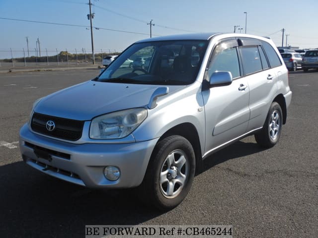 A grey JDM sports car speeding down a highway at night.