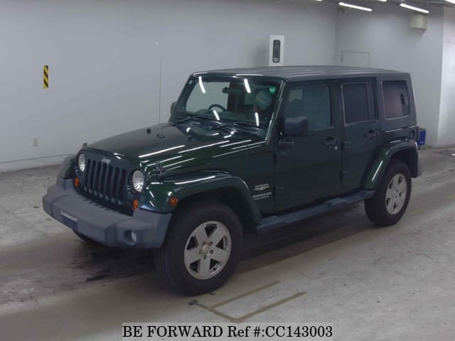 A grey sports car speeding down a highway at night.