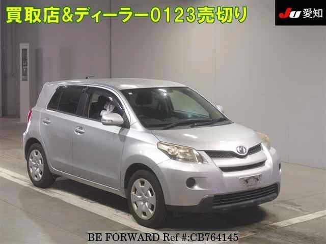 A grey JDM sports car speeding down a highway at night.