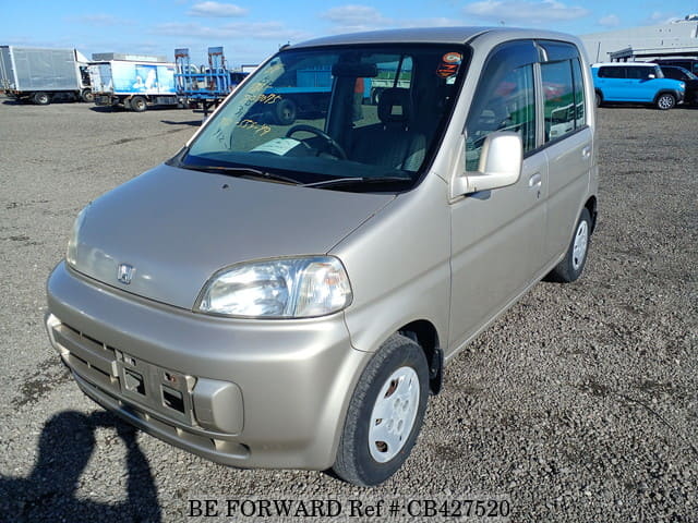A grey JDM sports car speeding down a highway at night.