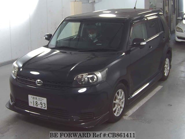 A grey JDM sports car speeding down a highway at night.