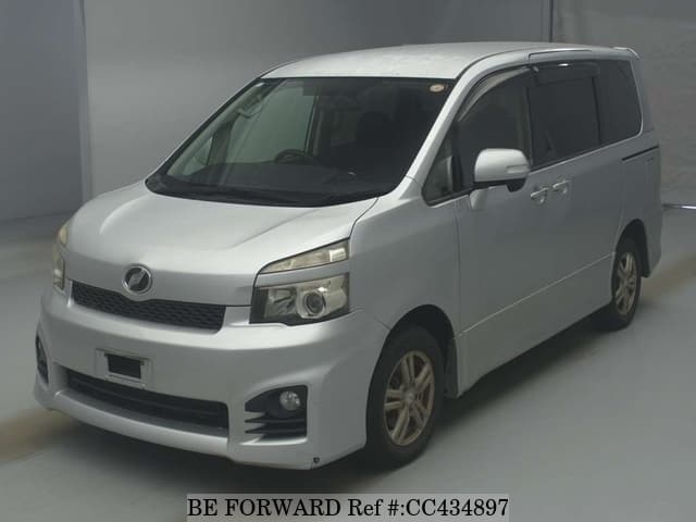 A grey JDM sports car speeding down a highway at night.