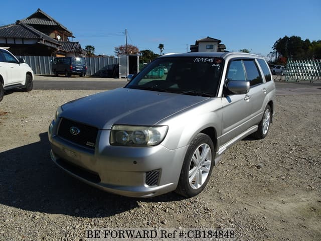 A grey JDM sports car speeding down a highway at night.