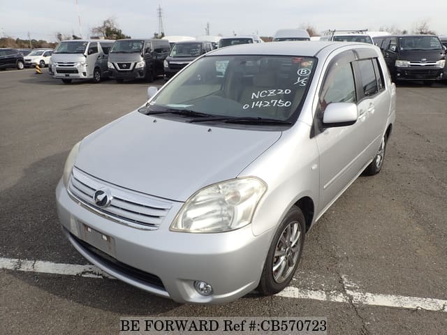 A grey JDM sports car speeding down a highway at night.