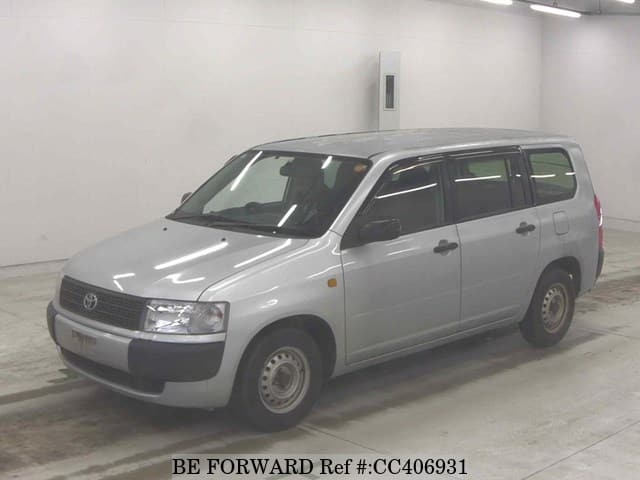 A grey sports car speeding down a highway at night.