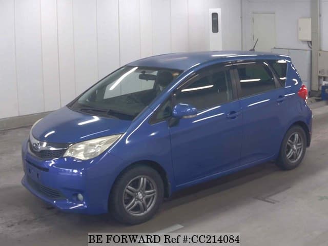 A grey sports car speeding down a highway at night.