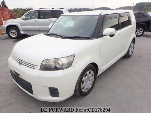 A grey sports car speeding down a highway at night.