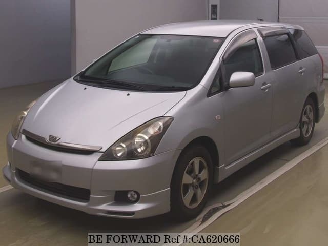 A grey JDM sports car speeding down a highway at night.