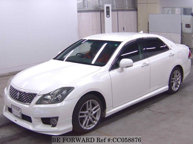 A grey sports car speeding down a highway at night.