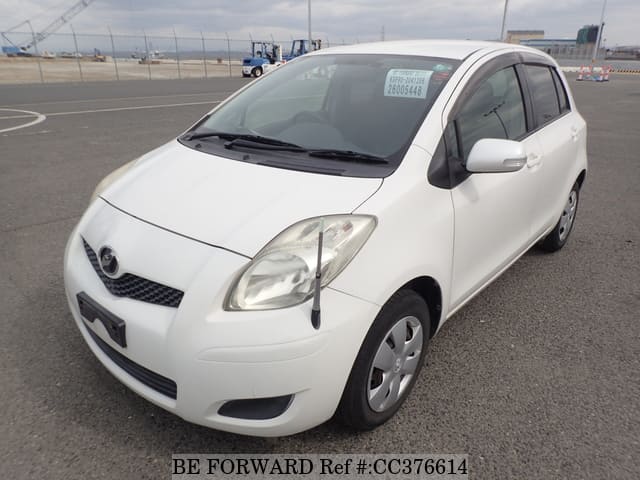 A grey sports car speeding down a highway at night.