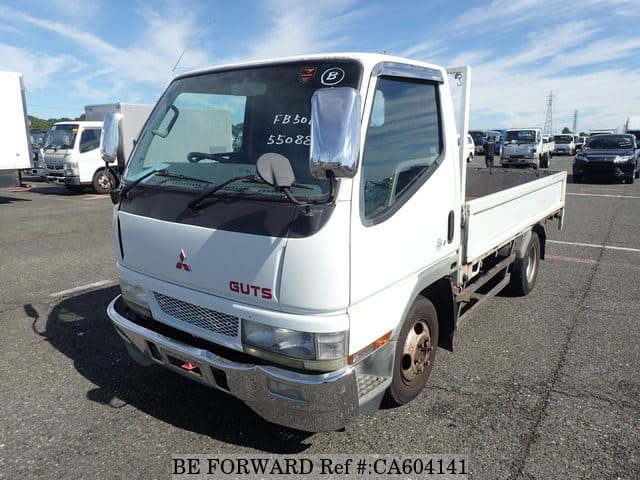 A grey JDM sports car speeding down a highway at night.
