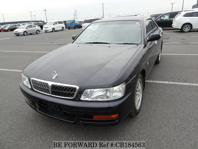 A grey sports car speeding down a highway at night.