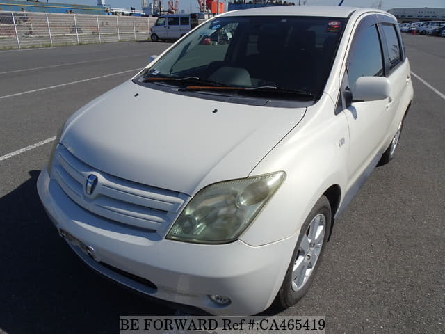 A grey JDM sports car speeding down a highway at night.