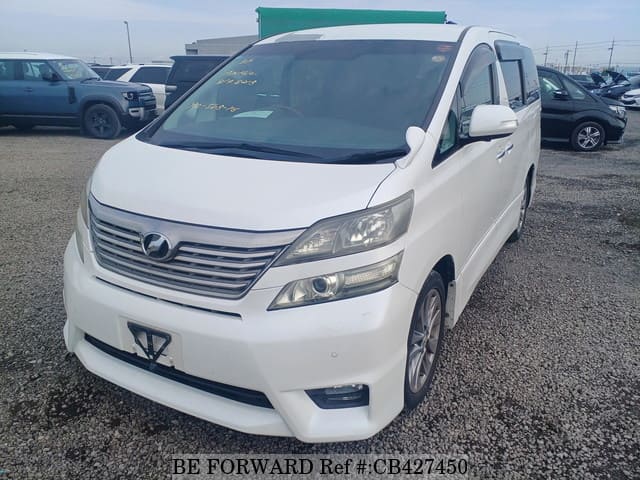 A grey JDM sports car speeding down a highway at night.