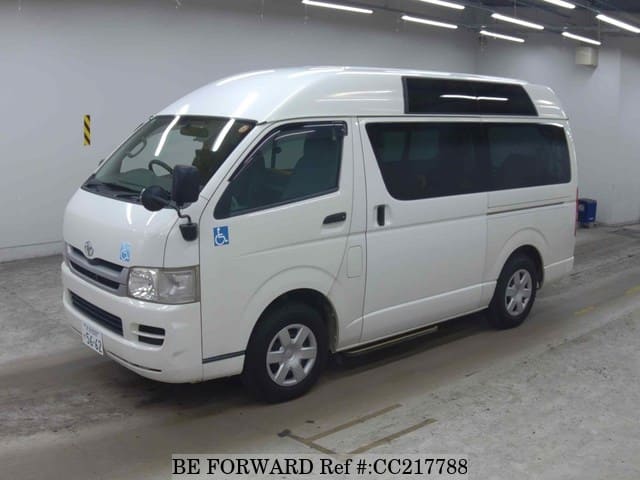 A grey sports car speeding down a highway at night.