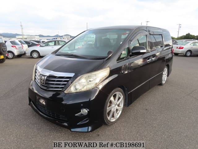 A grey JDM sports car speeding down a highway at night.