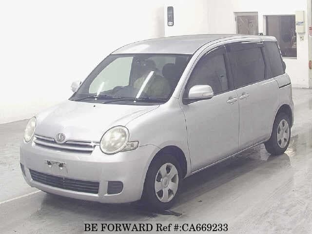 A grey JDM sports car speeding down a highway at night.