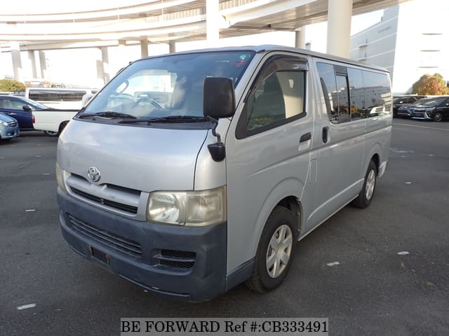 A grey JDM sports car speeding down a highway at night.